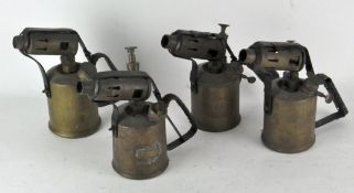 A group of four vintage blow torches
