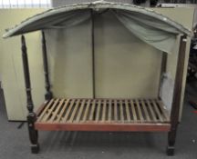 A vintage single four poster bed with wooden slats and worn headboard;