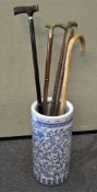 A ceramic blue and white umbrella/stick stand; together with five assorted walking sticks,
