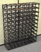 A modern metal and wood stacking wine bottle rack, with space for 76 bottles,