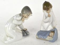 Two Lladro figures, an angel above a child, and another,
