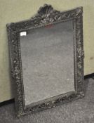 A cast metal framed wall mirror, in the rococo style with acanthus leaves and scroll decoration,
