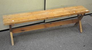 A contemporary pine bench raised on 'X' frame legs with stretcher. 45cm x 152cm x 29cm.