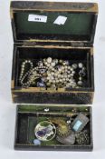 A vintage jewellery box containing costume jewellery,