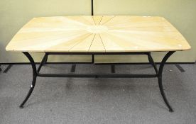 A modern 'sunburst' style table, raised on metal supports,