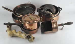 A group of assorted copper cookware, including saucepans, kettle,