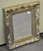 A gilt framed wall mirror, with floral motif adorning the border,