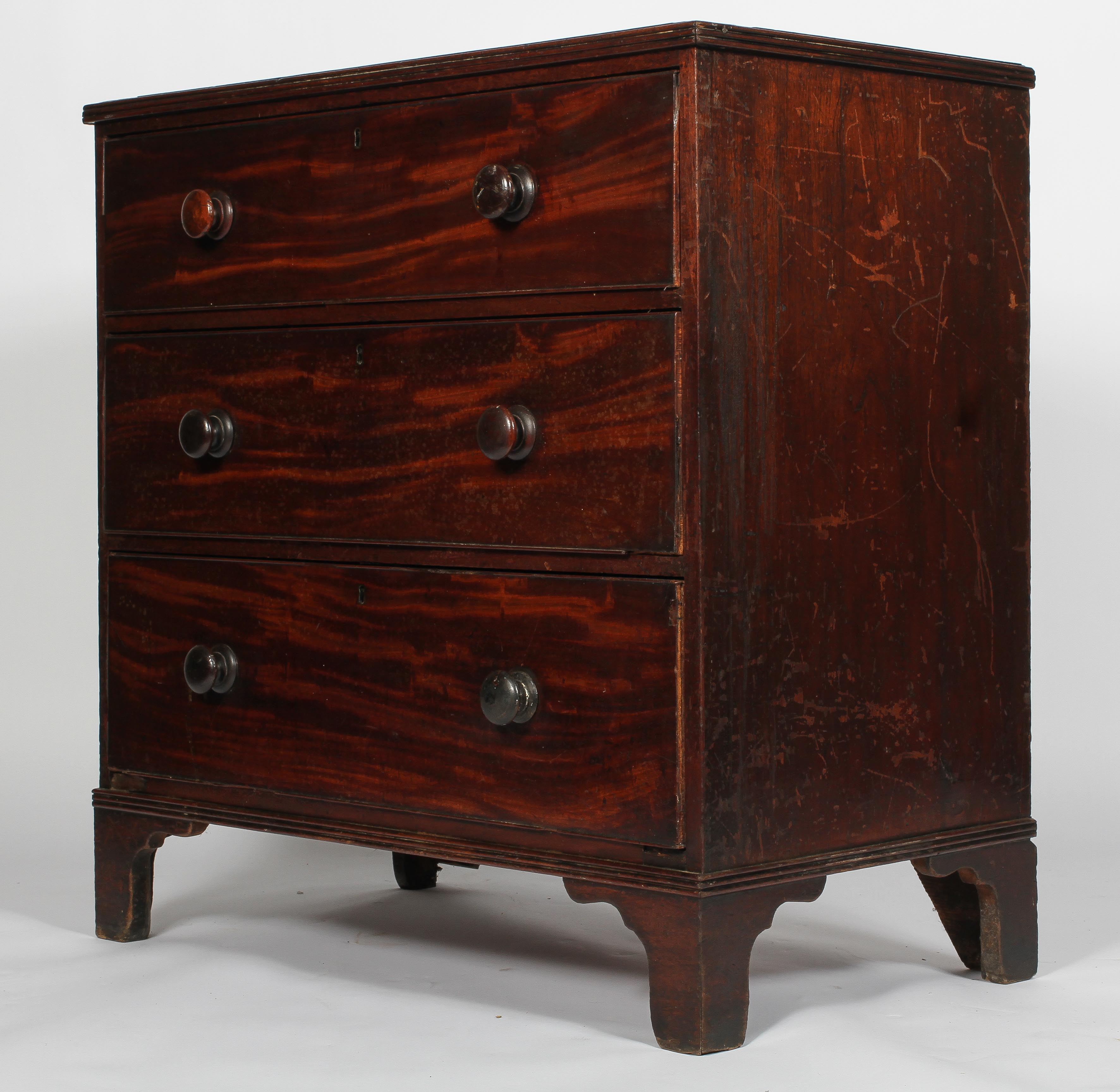 A George III mahogany chest of three graduated long drawers, with turned pulls,