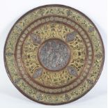 An Indian copper, brass and white metal charger, with applied decoration of various deities,