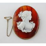 A large banded agate brooch with carved cameo. In a yellow metal rope edge mount.