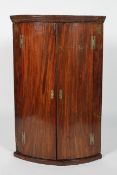 A George III mahogany bow fronted two door corner cabinet,