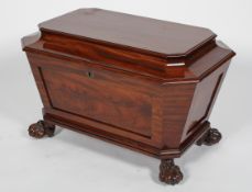 A George III mahogany wine cooler, of canted rectangular form on lion paw feet,