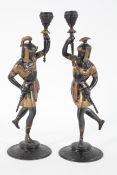 A pair of Spelter figure candlesticks, cast as warriors holding up torches, with gilt highlights,