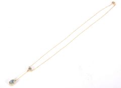 An unmarked yellow metal necklace with fitted two drop Aqua marine pendant, appears to be 9ct gold,