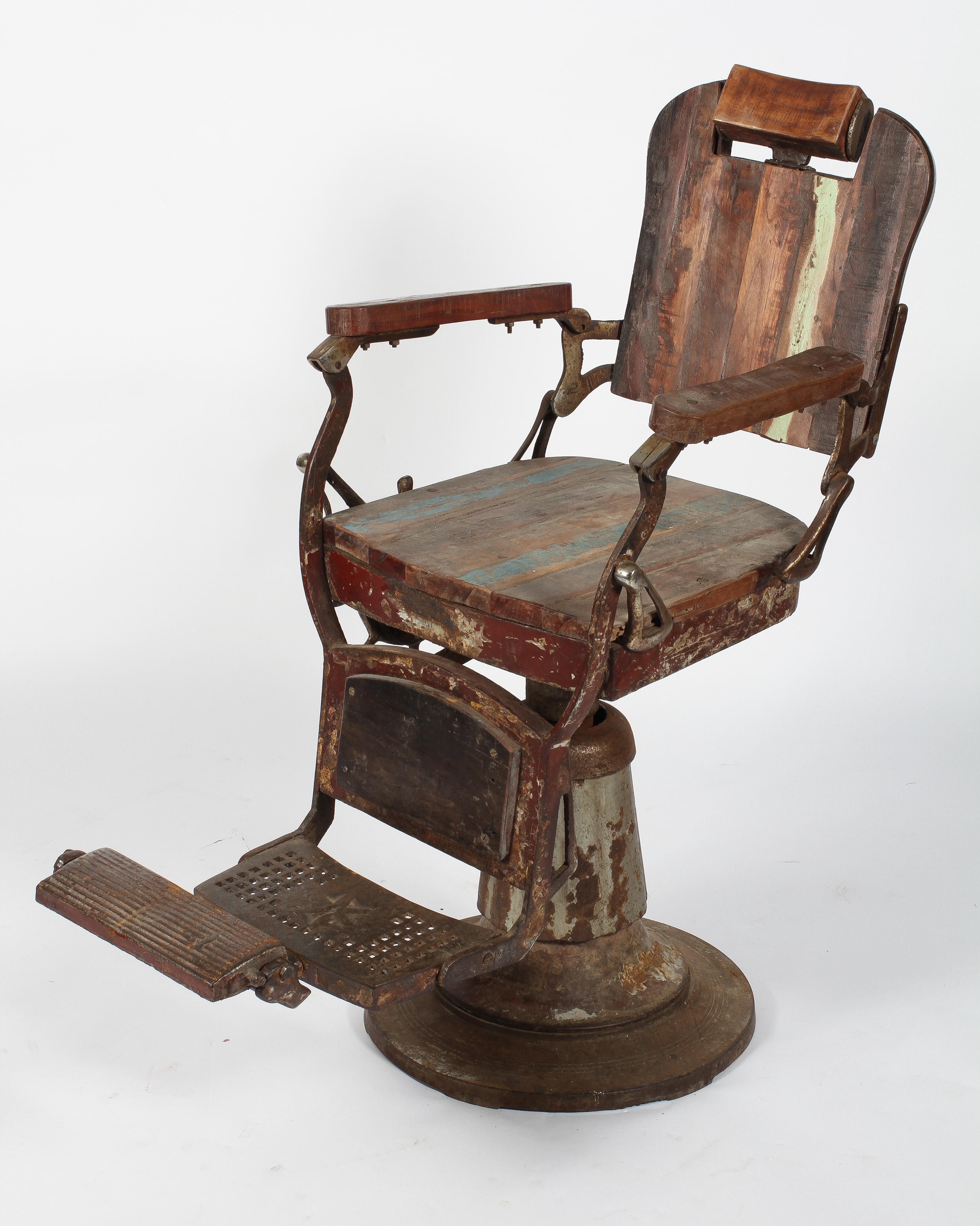 A vintage stripped wood and metal barber's chair, with revolving seat,