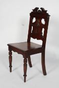 A Victorian walnut hall chair, with foliate carved and pierced back, solid seat and turned legs,