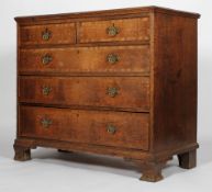 A George III oak and walnut cross banded chest of two short and three graduated long drawers,