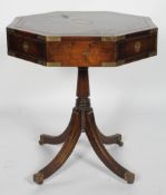 A campaign style mahogany and brass, octagonal revolving drum table, with four drawers,