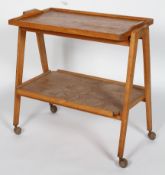 A Remploy mid 20th Century vintage golden oak two tier drinks trolley having a detachable tray tier