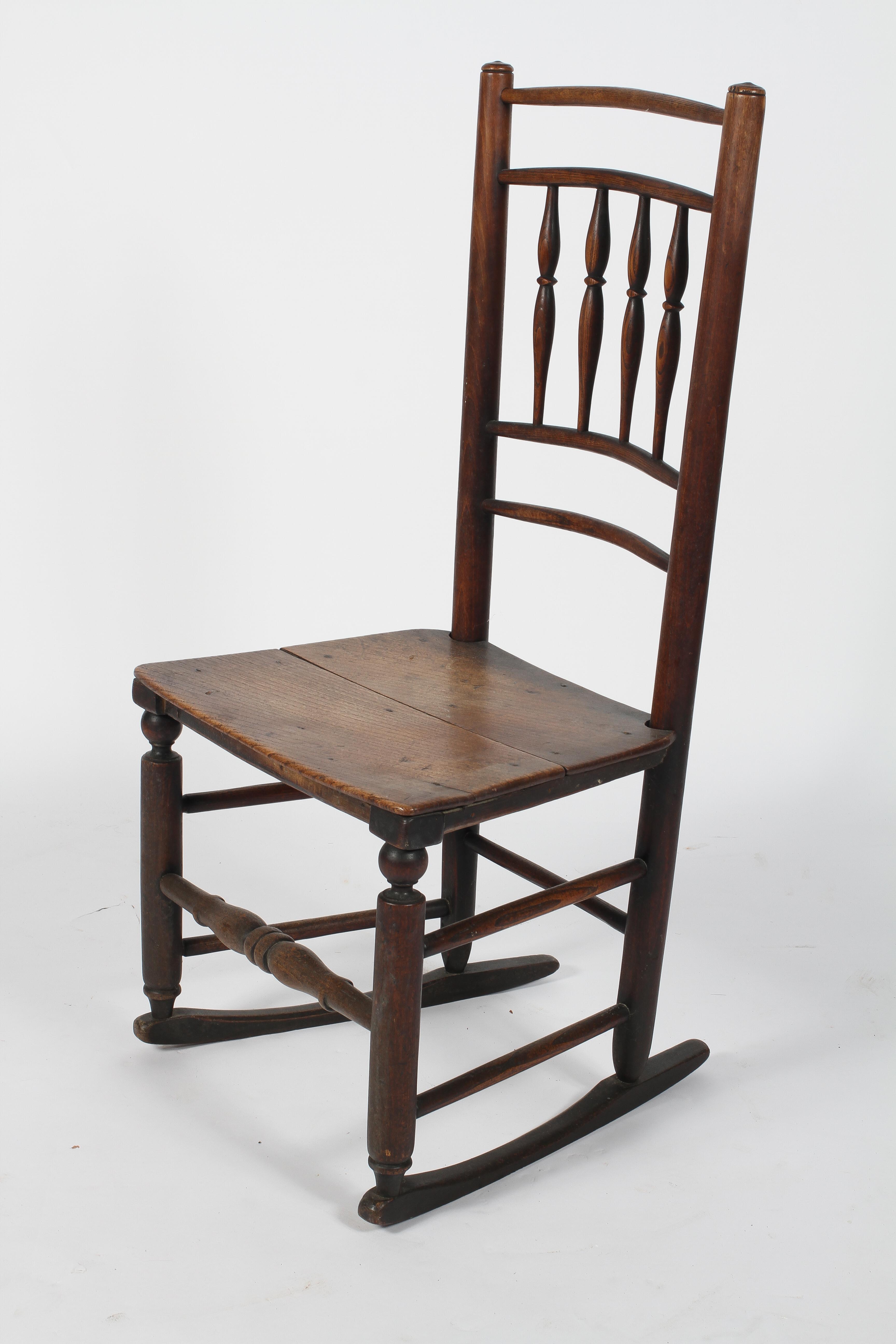 An ash and elm rocking chair, 19th century, with spindle back, two plank seat and box stretched,