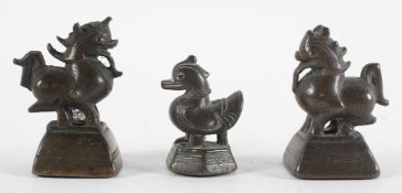 A group of three bronze opium weights, probably Chinese, in the form of a duck and two dragons,