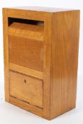 A 1960's golden oak possibly Air Corps internal letter box with hinged door and opening above,