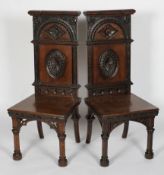 Two Victorian carved stained oak high backed hall chairs, circa 1880,