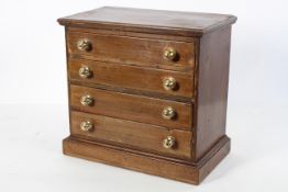 A mahogany collectors cabinet, modelled as a miniature chest of four long drawers,