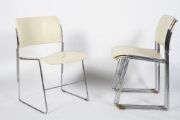 A set of four David Howe 20th Century vintage metal stacking chairs having white finished backrest