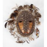 Tribal Art : A Lega mask, of shells and feathers applied to a tortoiseshell, 25cm high (total,