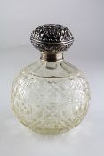A silver capped glass scent bottle, with scrolling foliate decoration,