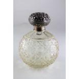 A silver capped glass scent bottle, with scrolling foliate decoration,