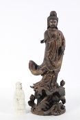 A South East Asian or Chinese carved wood figure of Quanyin with painted and gilt decoration,