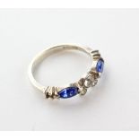 A half hoop ring set with blue and white paste stones.