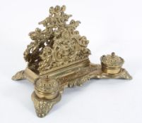 A Victorian brass desk stand, with pierced scrolling foliage above two inkwells,