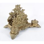 A Victorian brass desk stand, with pierced scrolling foliage above two inkwells,