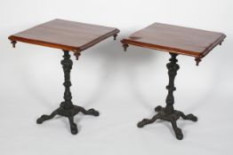 A pair of mahogany and cast iron tables, the rectangular top on foliate cast bases,