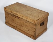 A Victorian pine trunk, perhaps originally a carpenter's, with hinged cover and iron swing handles,