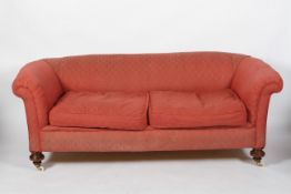 A 19th century Chesterfield two seat sofa, upholstered in red, with two drop-in cushions,