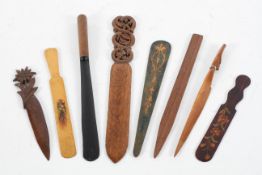 A collection of eight wood page turners with carved and painted decoration,