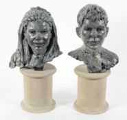 A pair of cast and patinated metal busts of a boy and girl, initialled SJ'01,