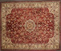 A Belgian machine made carpet of oriental design, a grey cartouche on a red ground,