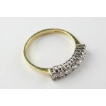 A yellow and white metal half hoop ring set with seven round brilliant cut diamonds