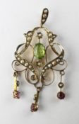 An Edwardian filigree pendant set with peridot and rhodolite garnet and finished with seed pearls.