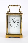 A French brass carriage time piece, with an enamelled dial and eight day movement,