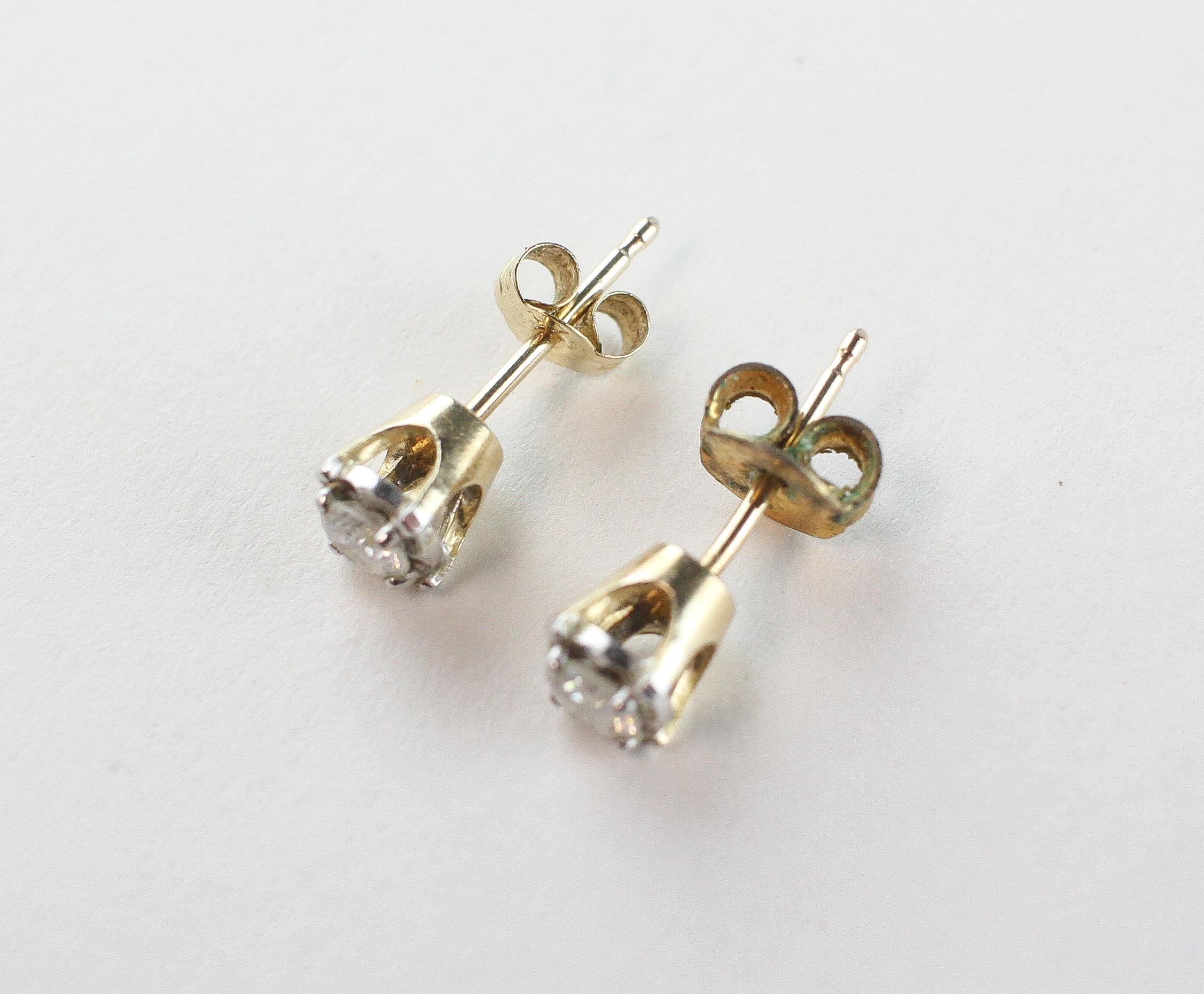 A yellow and white metal pair of stud earrings.