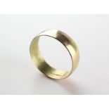 A yellow metal 7.5mm D shape wedding ring. Hallmarked 9ct gold, London, 1973.