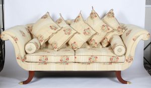 A Regency style sofa, the camel back above scrolling arms, loose cushion seat and fluted sabre legs,