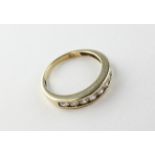 A yellow metal half hoop ring set with nine round cubic zirconias. Hallmarked 9ct gold, Birmingham.