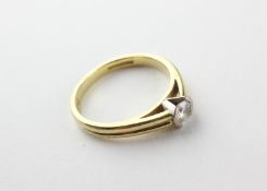 A yellow and white metal single stone ring.